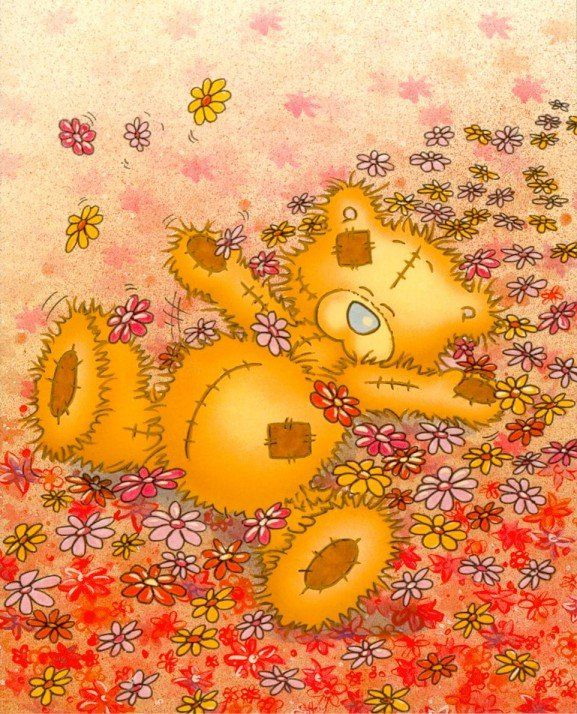Мишка Тедди лежит на поляне из цветов
